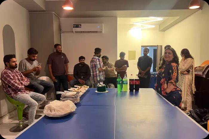The team standing around the table with food and drinks