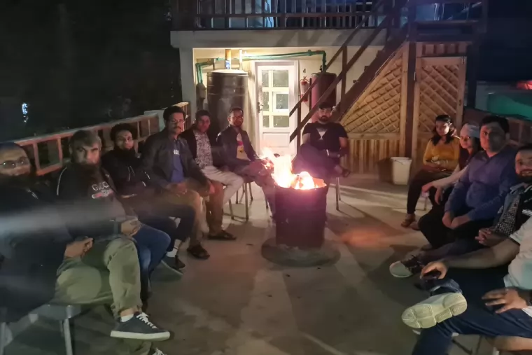 The team sitting together around a fire pit in the evening