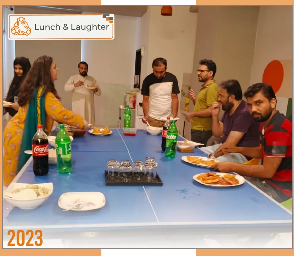 2023 — Lunch & Laughter: the team sharing lunch around the office table.